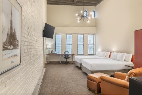 a hotel room with two beds and a couch at Sonesta Columbus Downtown in Columbus