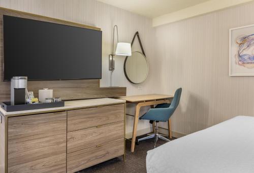 a hotel room with a desk and a flat screen tv at Sonesta Columbus Downtown in Columbus