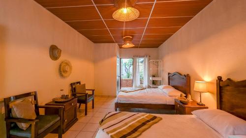a bedroom with two beds and a table and a chair at Cien Fuegos Hostel in Salcoatitán