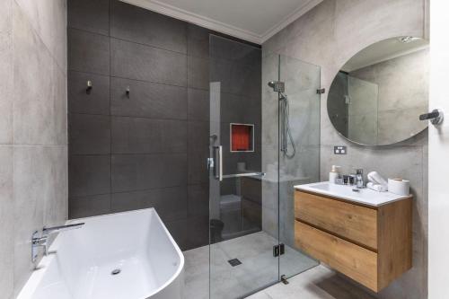 a bathroom with a tub and a sink and a shower at Hillhouse in Myrtleford