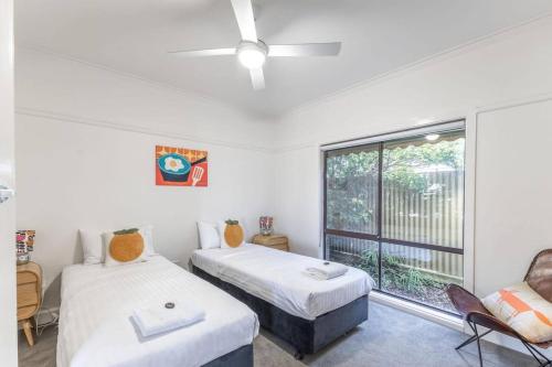 a bedroom with two beds and a window at Hillhouse in Myrtleford