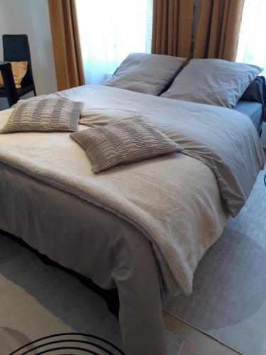 a large bed with two pillows on top of it at TINCHEBRAY Centre ville in Tinchebray
