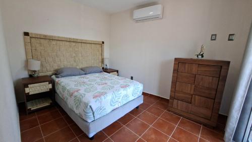 a bedroom with a bed and a wooden dresser at Bungalows Huerta del Mar in San Blas