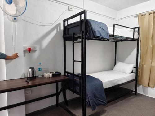 a room with two bunk beds and a desk at Heijo's Travellers Nest in Jarain