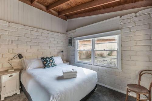 a bedroom with a bed and a window at Gangurru in Myrtleford