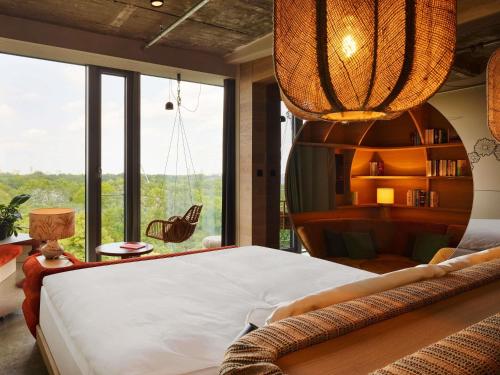 a bedroom with a large bed and a large window at 25hours Hotel Bikini Berlin in Berlin