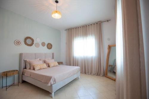 a bedroom with a bed and a window and a mirror at Villa Aura in Ouled Yaneg