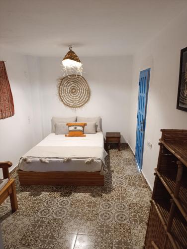 a bedroom with a bed and a blue door at daryemma2 in Asilah