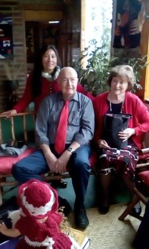 a man in a red tie sitting next to two women at Hospedaje Vertientes del Imbabura in Otavalo