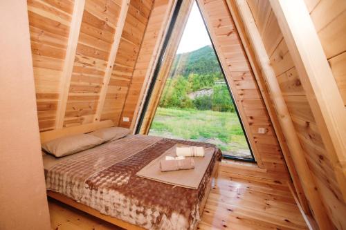 a bed in a room with a large window at Ujcevina Apartments in Donje Morakovo