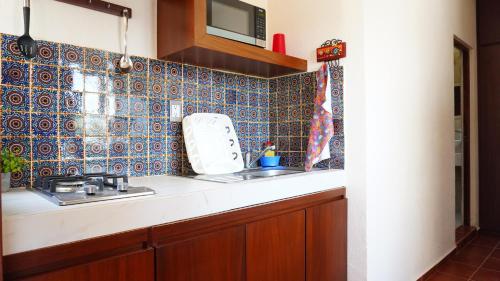 a kitchen with a sink and blue tiles on the wall at Bungalows Huerta del Mar in San Blas
