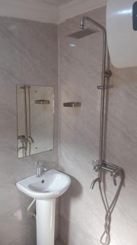 a bathroom with a sink and a shower at Summer Breeze Guest House in Suru Lere