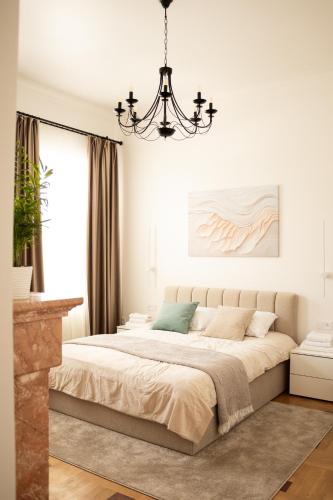 a bedroom with a large bed with a chandelier at Central Apartment Chortkiv in Chortkiv