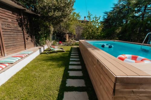 a backyard with a swimming pool and a lawn with chairs at DONNA LAURA - Holiday Home in Arezzo