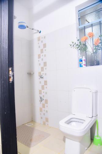 a bathroom with a toilet and a window at Savannah suites Bel-Air in Gilgil