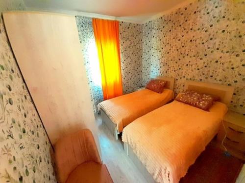 a room with two beds and a chair in it at Green House in Kobuleti