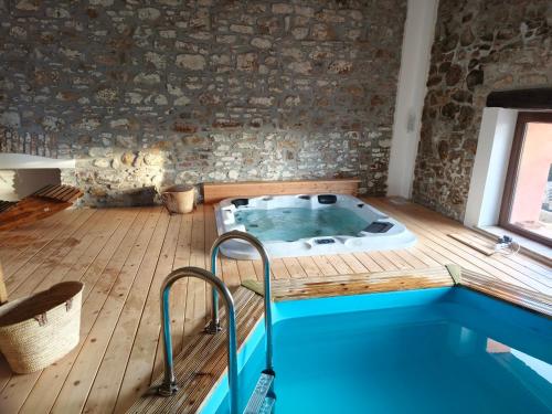 a jacuzzi tub in a room with a brick wall at Masseria Baglio Perciata in Camporeale