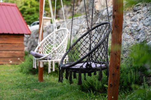 two chairs sitting on a swing in a yard at Vikendica,Bungalovi Lipska pećina in Cetinje