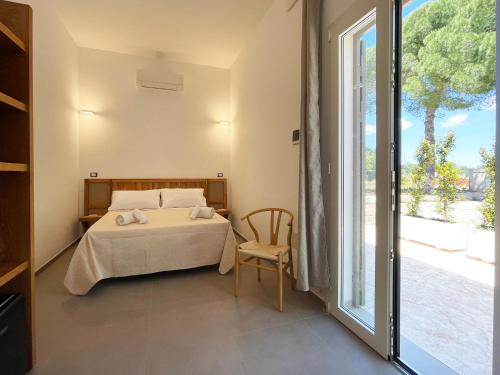 a bedroom with a bed and a large window at Dimora Thalèa - Retreat & Rooms in Nardò