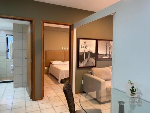 a hotel room with a bed and a couch at Flat no Condomínio Metrópolis - Ilha do Leite in Recife