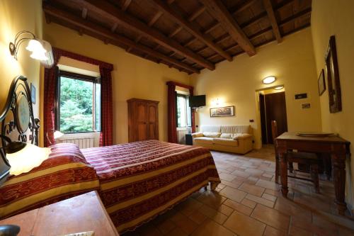 a bedroom with a bed and a couch in a room at Hotel Antico Casale in Vigarano Mainarda