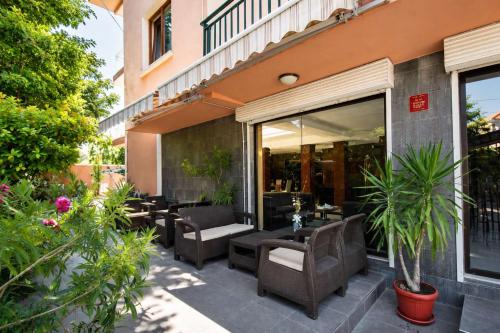 a patio with couches and chairs in front of a building at Family Hotel Kosko in Chernomorets