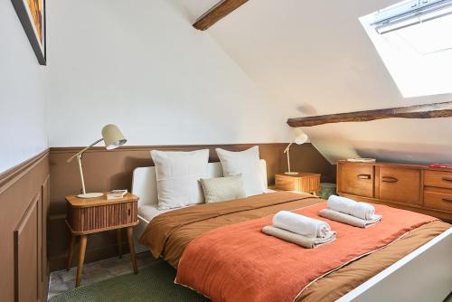a bedroom with a bed with two towels on it at Appartement Houdan centre-ville in Houdan