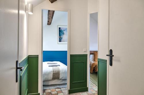 a bedroom with green doors and a bed in a room at Appartement Houdan centre-ville in Houdan