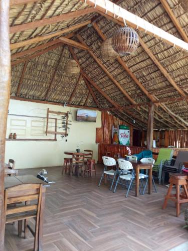 a restaurant with tables and chairs and a straw roof at Dreamland Tour in Santa Teresa