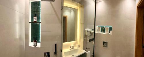 ein Badezimmer mit Waschbecken und Spiegel in der Unterkunft Tanger Miramonte - Resort Seaside Suites & Double Rooms in Tangier