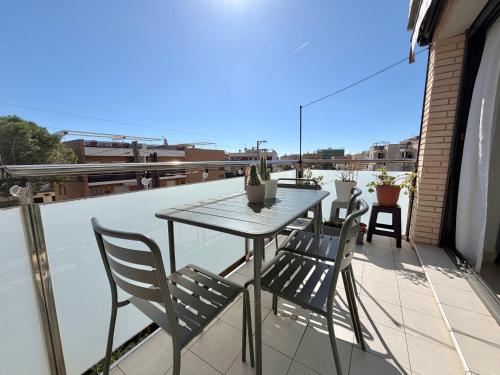a table and chairs on a balcony with a view at Ático en Cubelles playa in Cubelles