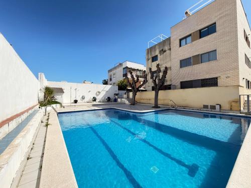 a swimming pool in front of a building at Ático en Cubelles playa in Cubelles