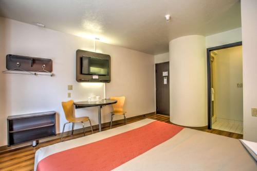 a bedroom with a bed and a table and a tv at Motel 6-Bozeman, MT in Bozeman