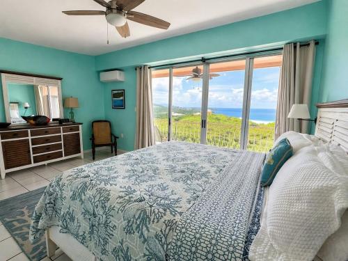 a bedroom with a bed and a view of the ocean at East End Escape in Christiansted