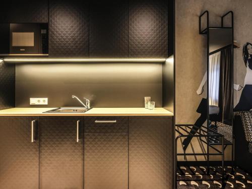 a kitchen with a sink and a microwave at ibis Styles Arnhem Centre in Arnhem