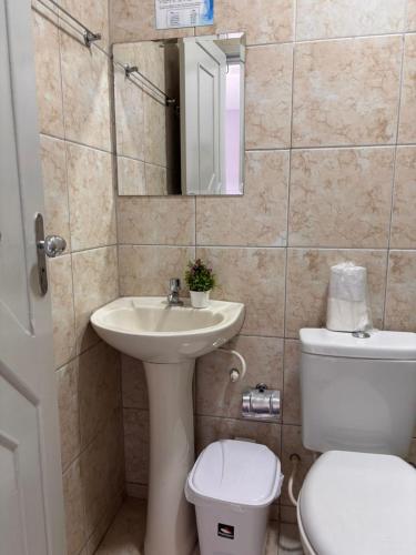 a bathroom with a sink and a toilet and a mirror at Pousada Planalto in Juazeiro do Norte