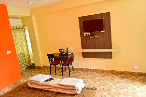 a room with a table and a television and towels at HOTEL SHREESH (NEIL) in Neil Island