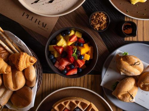 a table topped with plates of food and bowls of fruit at Pullman Lima Miraflores in Lima