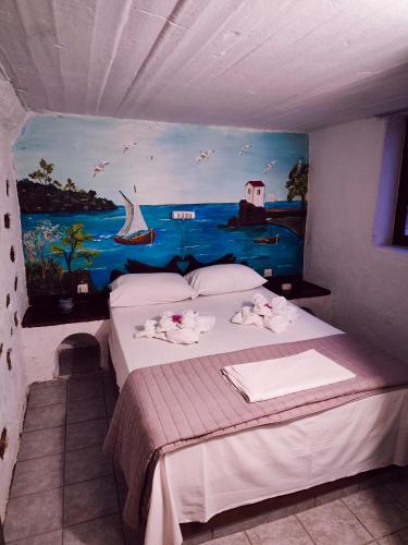 a bedroom with a bed with a painting on the wall at Hotel Eliza in Agios Nikolaos