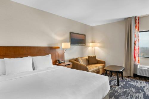 a hotel room with a bed and a couch at Fairfield Inn Boston Woburn in Woburn