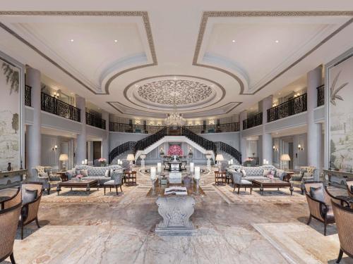 a large lobby with chairs and tables and a ceiling at Raffles Udaipur in Udaipur