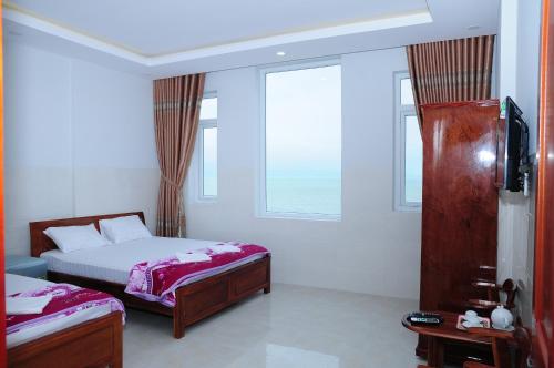 een slaapkamer met 2 bedden en een raam bij Gia Huy Guesthouse in Da Nang