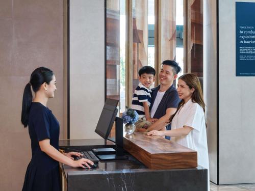 a group of people standing around a desk at Novotel Bangkok Future Park Rangsit in Bangkok