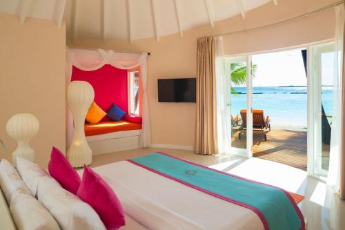 a bedroom with a bed with a view of the ocean at Sun Siyam Vilu Reef - 24 Hours All-Inclusive with Free Transfer in Dhaalu Atoll