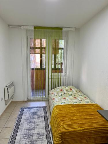 a bedroom with a bed in a room with a window at WISH Apartment Sarajevo in Sarajevo
