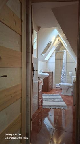 an attic bathroom with a sink and a toilet at U Bizioma in Murzasichle
