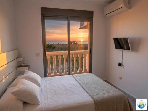 a bedroom with a bed and a large window at Adosado Primera línea de mar Playa de Puzol con Piscina y terrazas in Playa de Mar