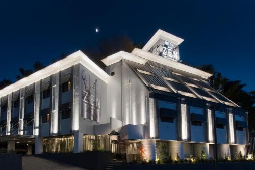 a large white building with a clock tower at night at ホテル ゼン町田 in Machida