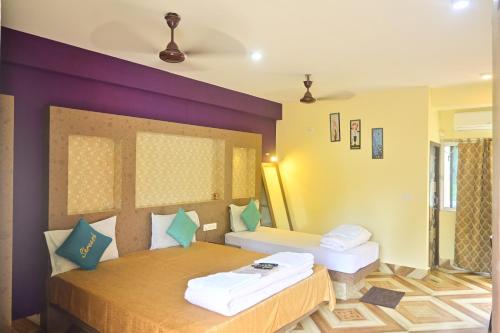a bedroom with a bed and a purple wall at HOTEL SHREESH (NEIL) in Neil Island