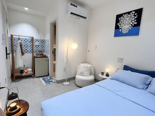 a bedroom with a bed and a chair in it at Cỏ Lá Homestay in Danang